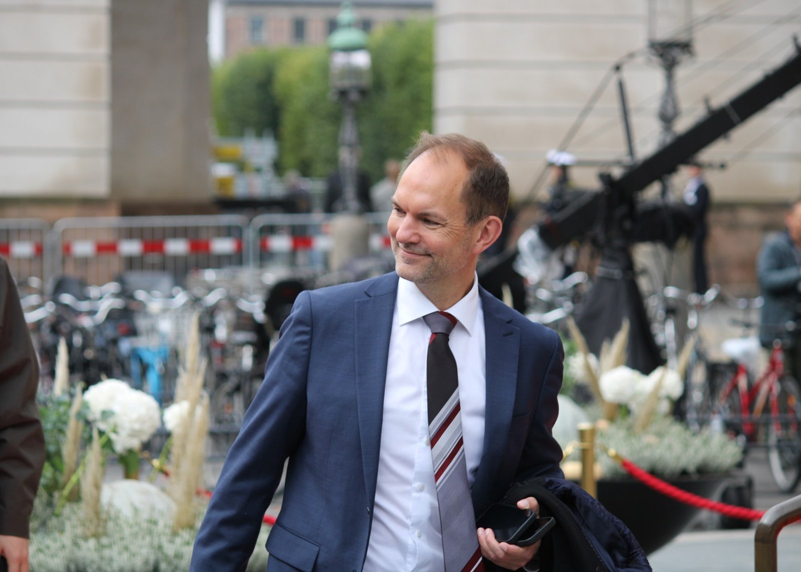 Forsvarsminister Jeppe Bruus i mørkeblå jakkesæt i Rigsdagsgården ved Christiansborg