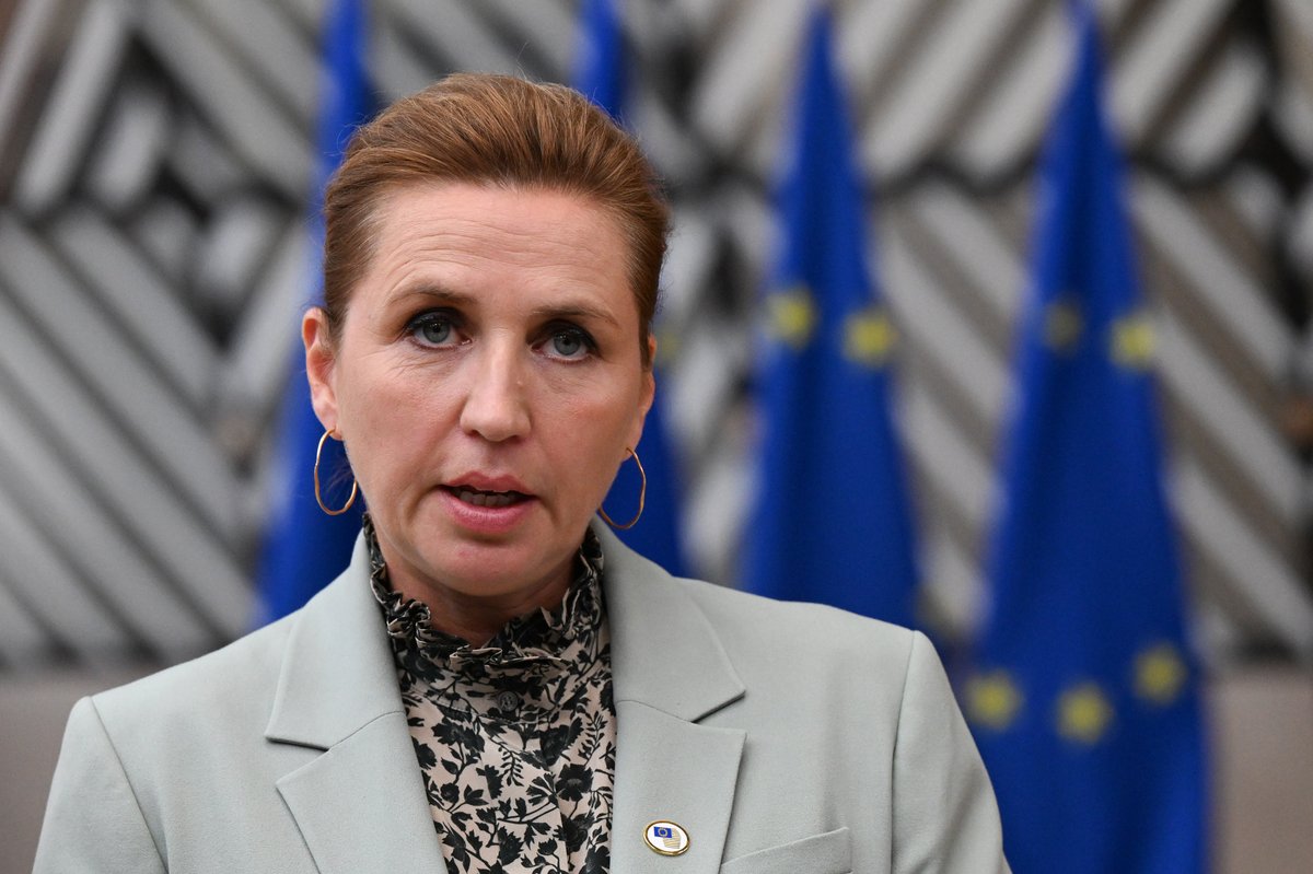Statsminister Mette Frederiksen i lysegrøn jakke taler til pressen foran EU-flag i Europa-bygningen i Bruxelles