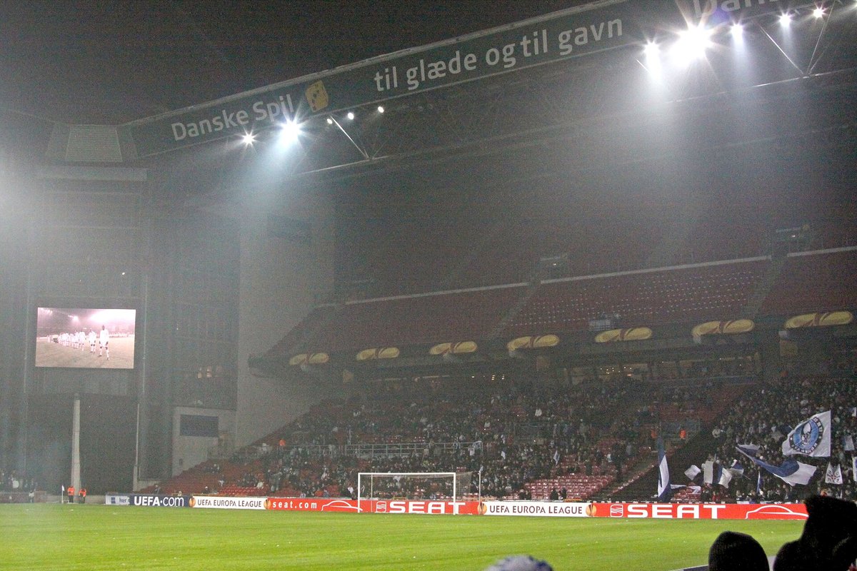 Parken under en Europa League-kamp om aftenen med et stort banner over tribunen, hvor der står "Danske Spil – til glæde og til gavn"